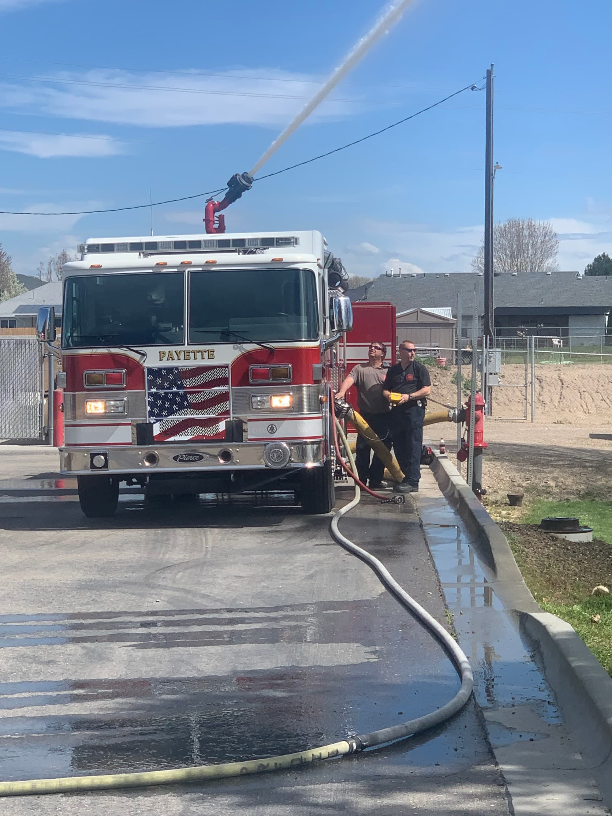 A Payette engine working a scene with charged hose lines on the street