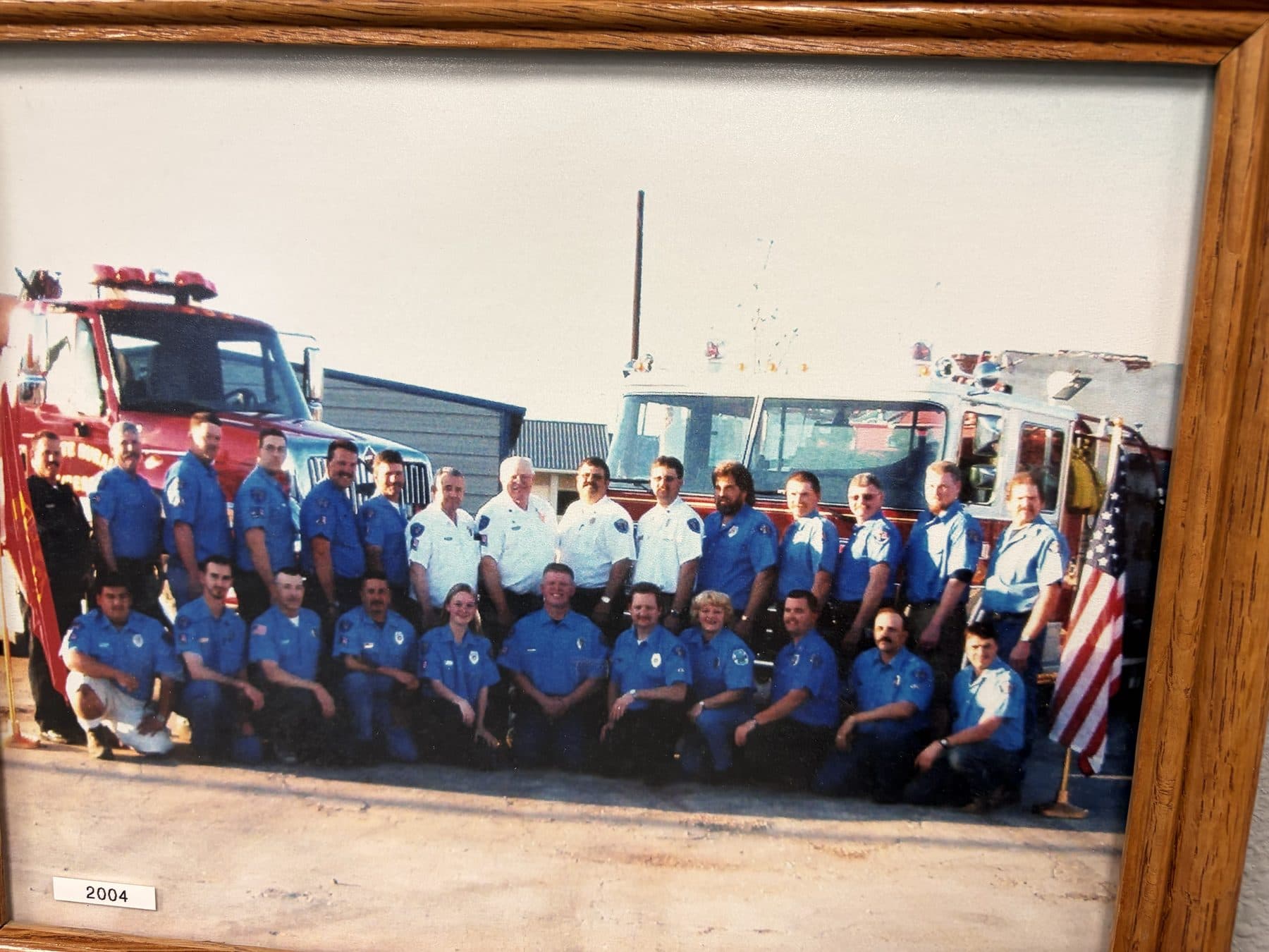Payette Fire Department 2004 crew photo in blue uniforms in front of fire apparatus and an American flag