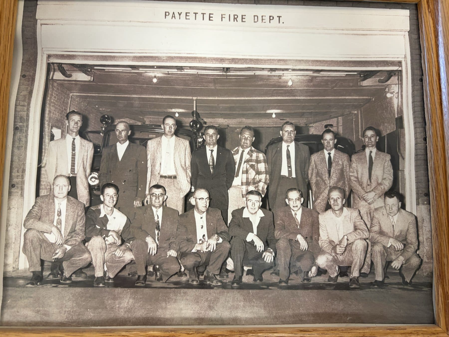 Black and white photograph of early Payette Fire Dept. members in suits and ties posed in front of the station
