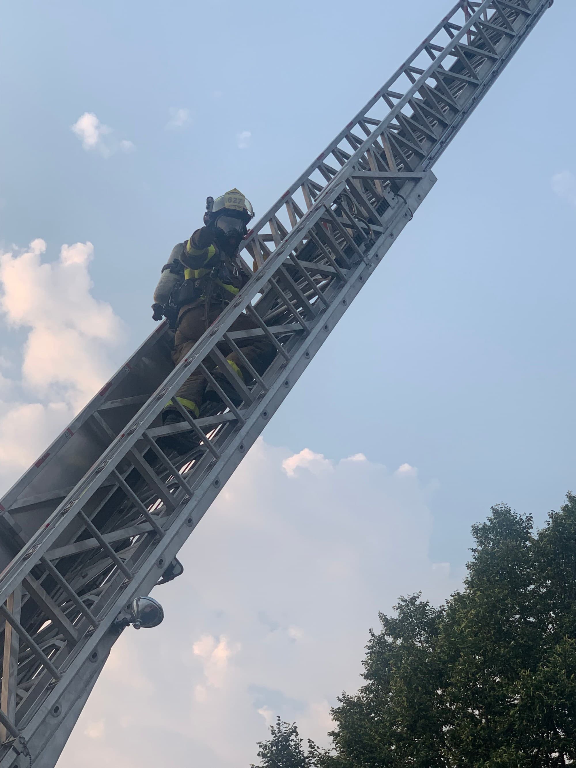 A Payette firefighter climbing the aerial ladder