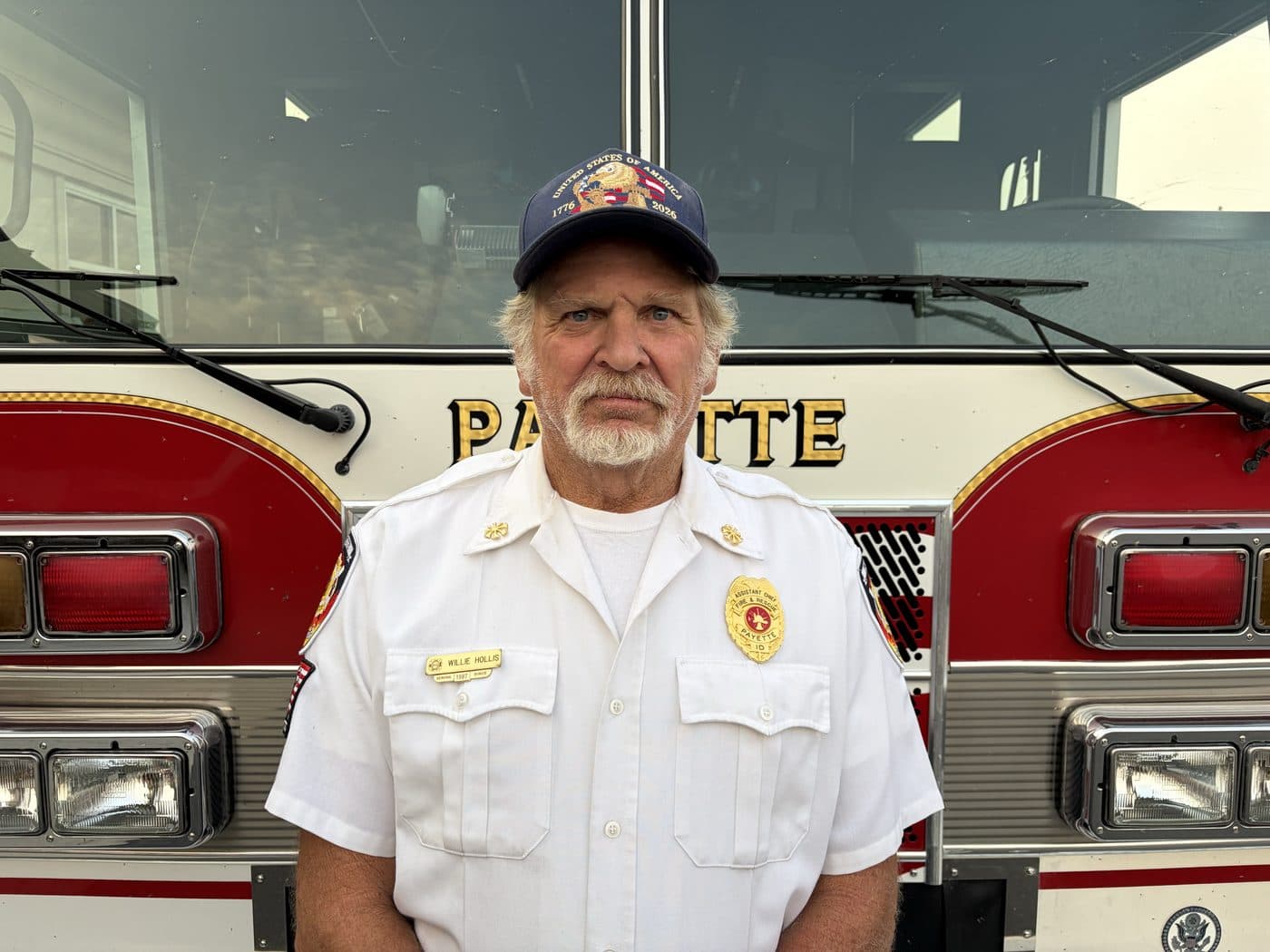 Assistant Chief Willie Hollis in dress uniform, standing in front of a Payette fire engine.